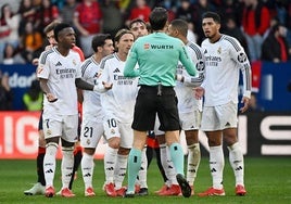 El árbitro José Luis Martínez Munuera, rodeado por jugadores del Real Madrid tras expulsar a Bellingham en Pamplona.