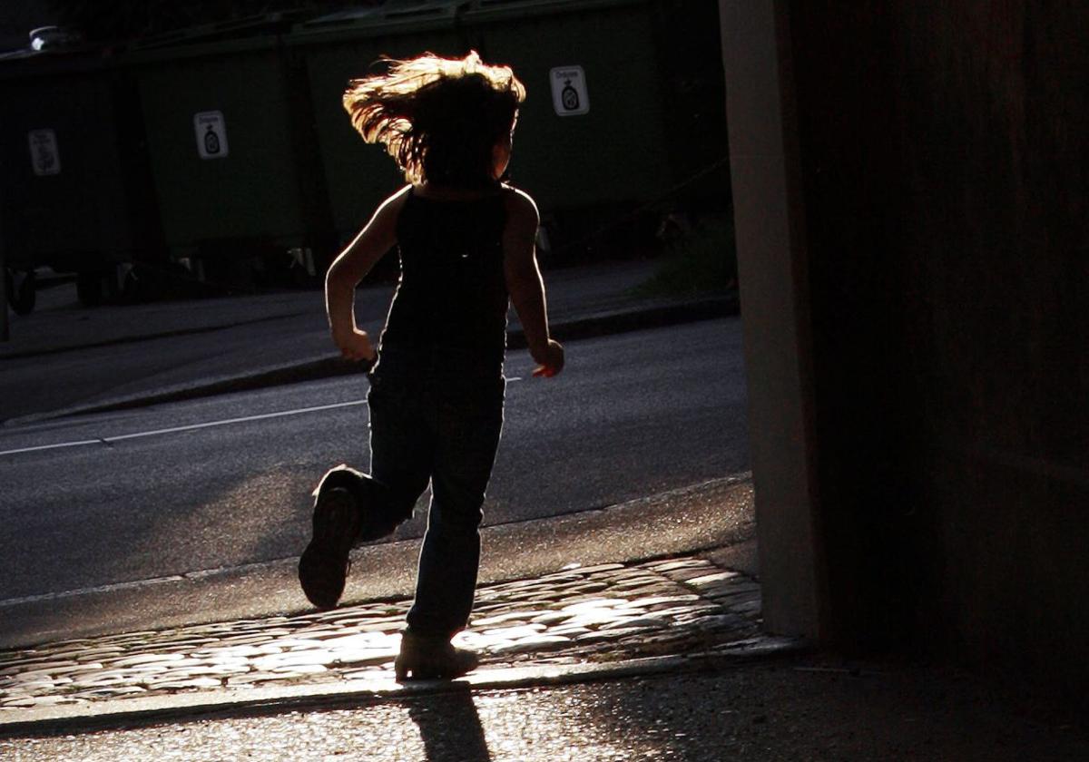 La silueta de una niña mietras corre.