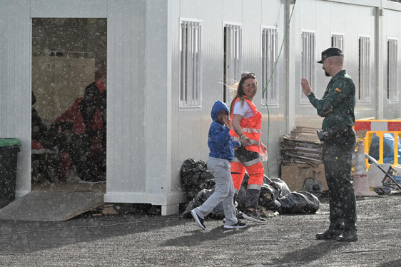 Un agente de la Guardia Civil saluda a un menor migrante llegado a España