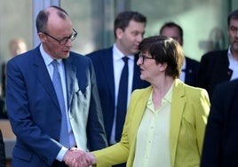 Apretón de manos entre el líder conservador, Friedrich Merz, y la copresidenta del SPD, Saskia Esken.