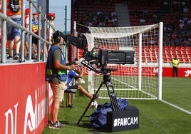 Cámara de televisión tomando imágenes de un partido de fútbol.