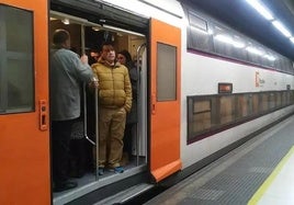 Un tren de Rodalies lleno en hora punta, esperando para retomar viaje en la estación barcelonesa de Sants.