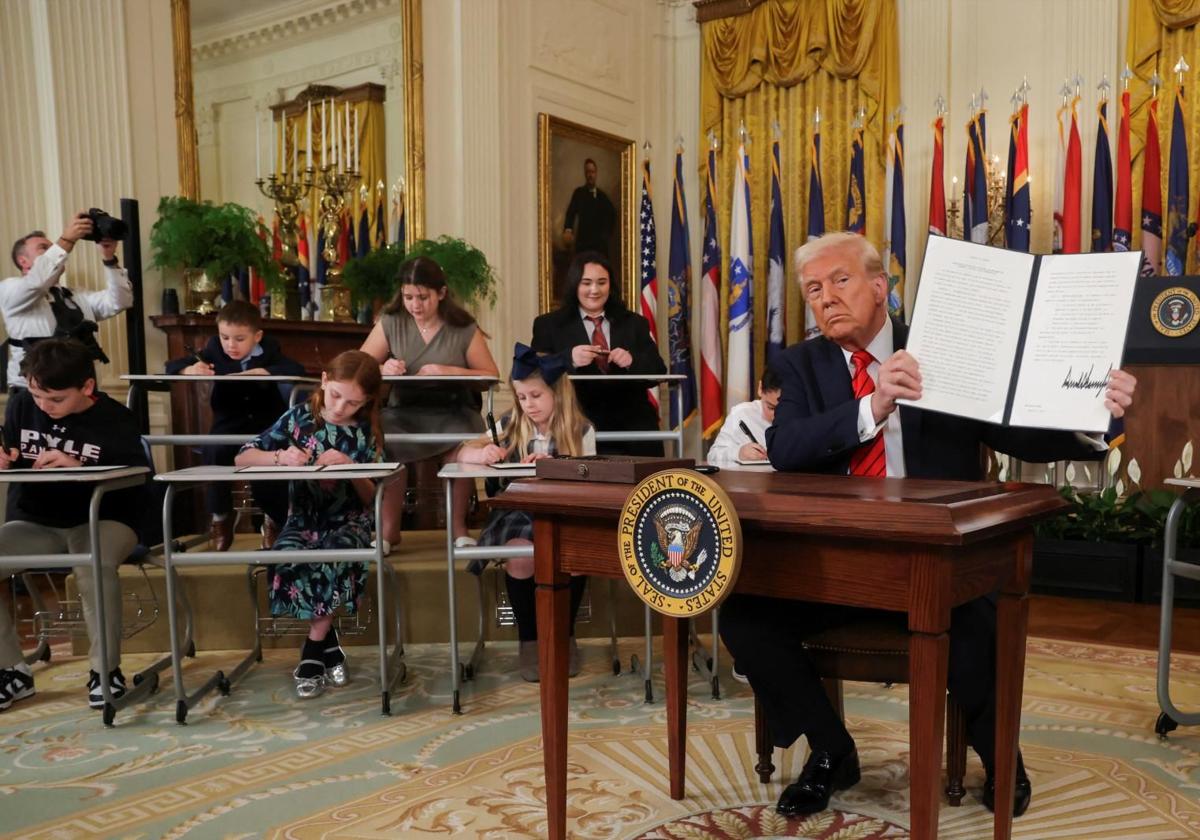 Donald Trump muestra su firma en una orden ejecutiva para cerrar el Departamento de Educación, durante un evento en la Sala Este de la Casa Blanca.