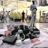 Un mantero ofrece artículos falsificados en una céntrica plaza de Granada.