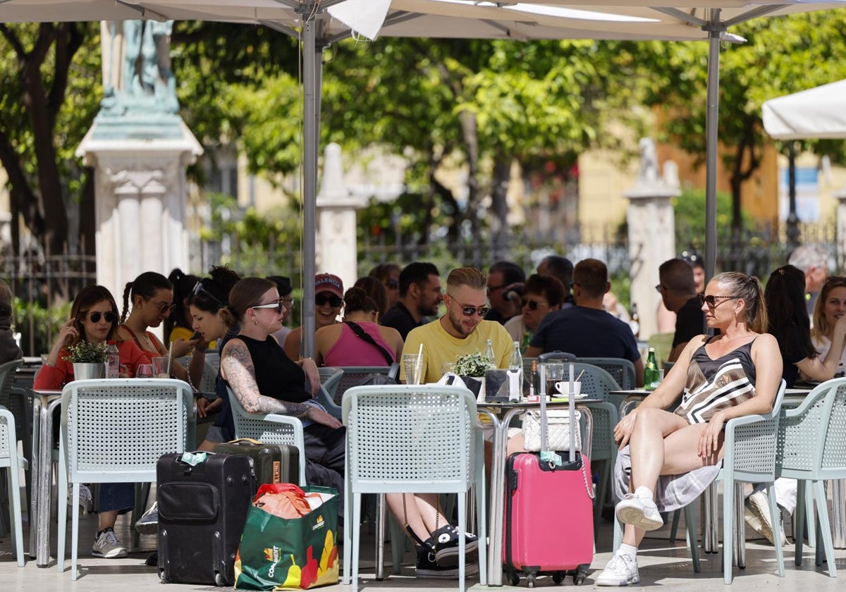 Several tourists enjoy the good weather on a bar terrace in Valencia.