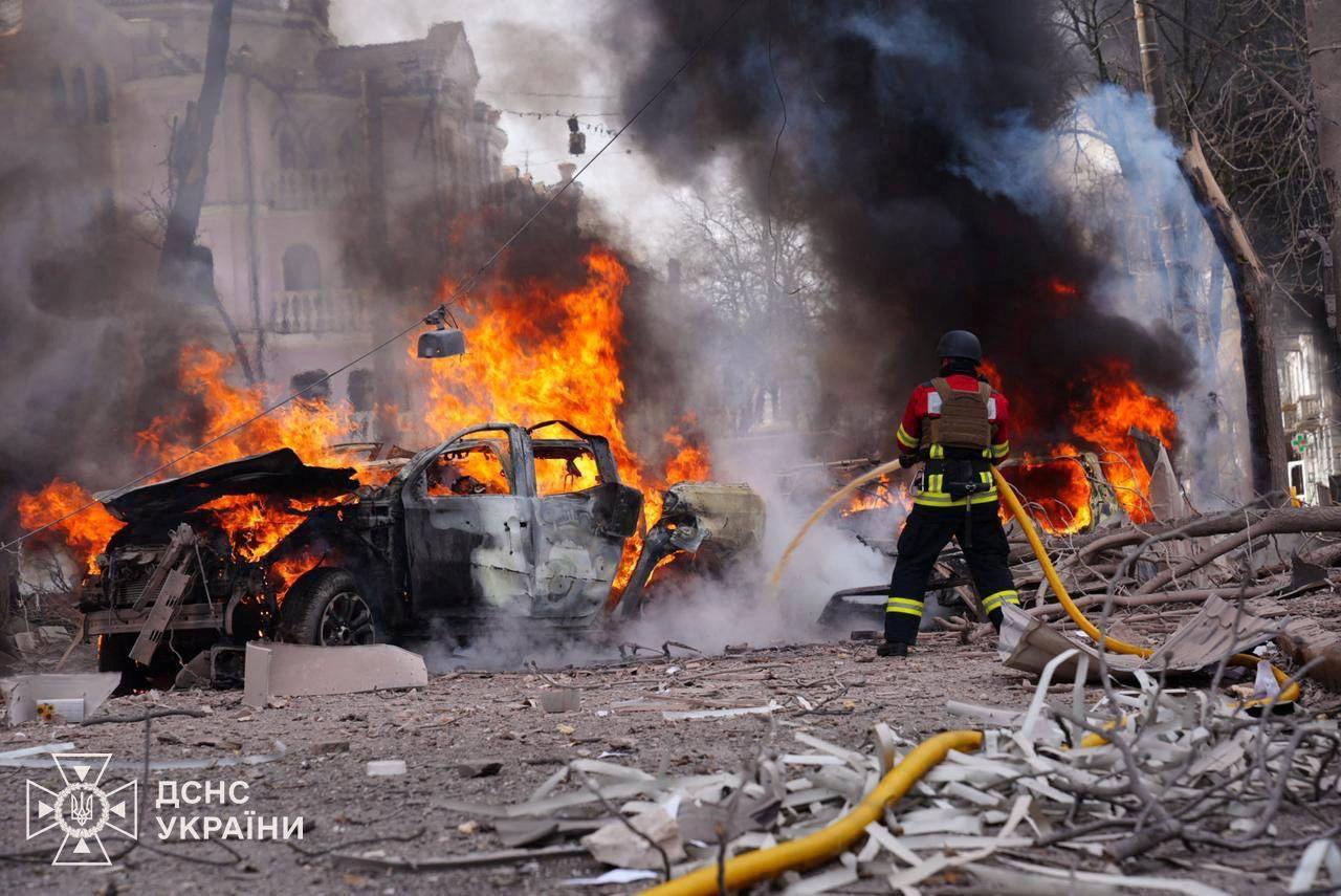 Un bombero apaga las llamas de un coche.
