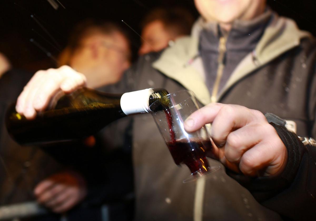 Un hombre se sirve un vaso de vino.