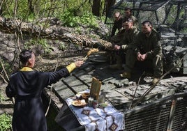 Un capellán bendice a varios soldados ucranianos durante la celebración de la Pascua en la zona de Zaporiyia.