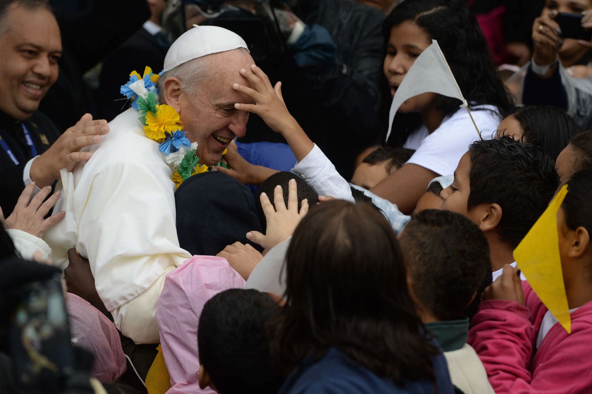 El papa Francisco está rodeado de niños mientras pasea durante su visita a la favela Varginha en Río de Janeiro, el 25 de julio de 2013. La favela Varginha es una comunidad de 1.000 personas que durante décadas estuvo bajo el dominio de los narcotraficantes hasta que quedó bajo control policial hace menos de un año. El primer pontífice latinoamericano y jesuita llegó a Brasil principalmente para la gran reunión católica de cinco días de la Jornada Mundial de la Juventud.