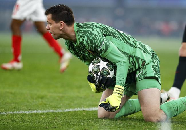 Wojciech Szczesny atrapa un balón rodillas en tierra.