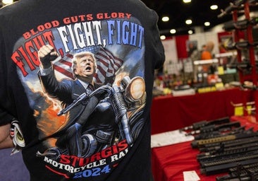 Un hombre con una camiseta de Trump en una armería.