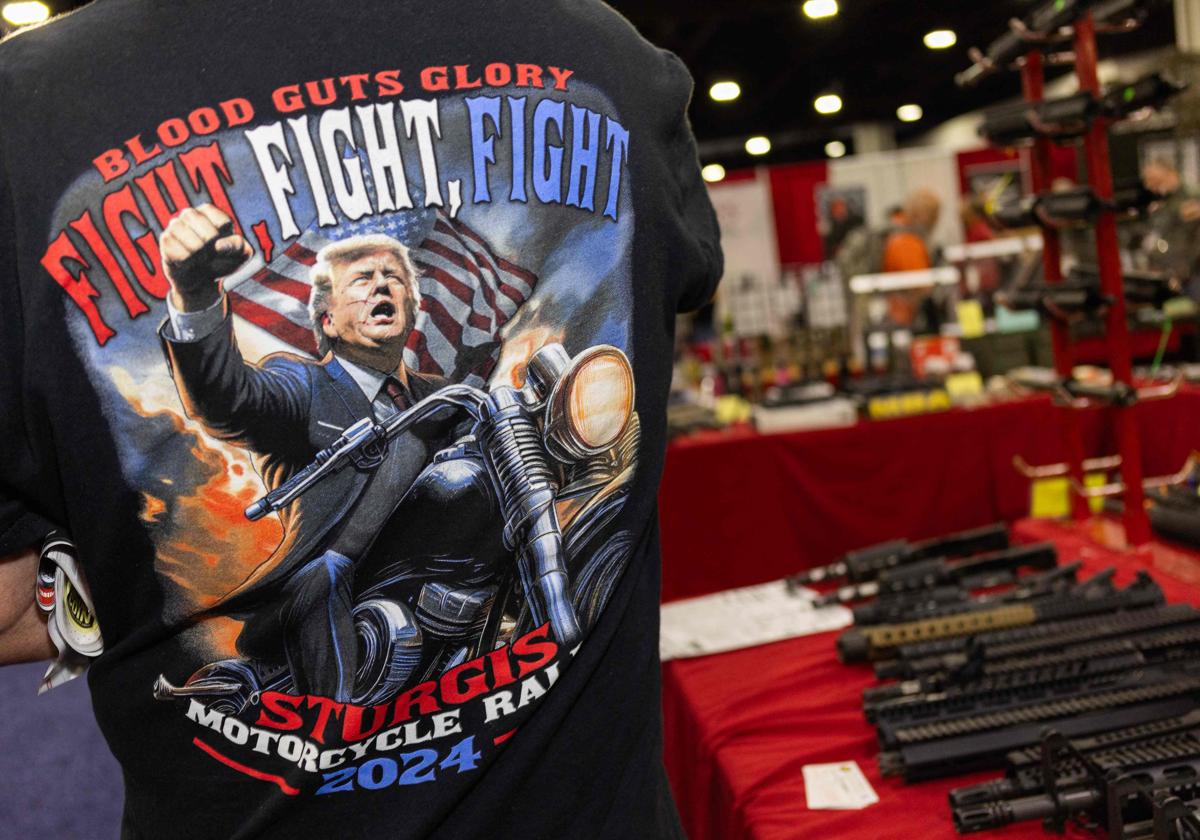 Un hombre con una camiseta de Trump en una armería.