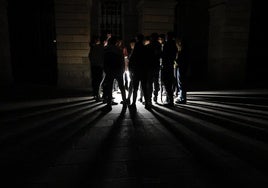 Jóvenes se reúnen frente a una catedral durante un apagón este martes, en Santiago de Compostela.