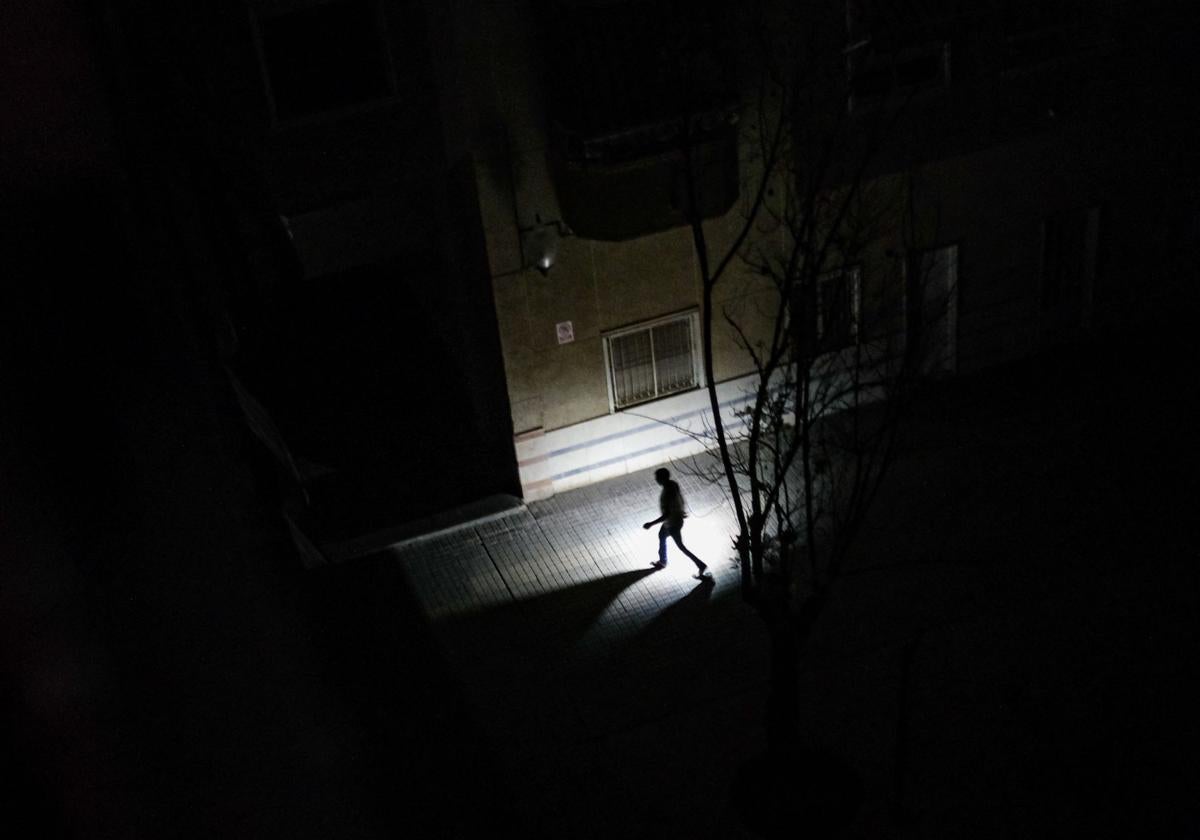 Un vecino de Elche camina con una linterna durante el apagón eléctrico que se ha producido este lunes en la Península Ibérica.