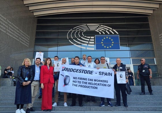 La eurodiputada socialista Idoia Mendia y el vicesecretario del PSOE de Cantabria, Javier Incera, acompañan a los trabajadores de Bridgestone, que posan con una pancarta frente al Parlamento Europeo.