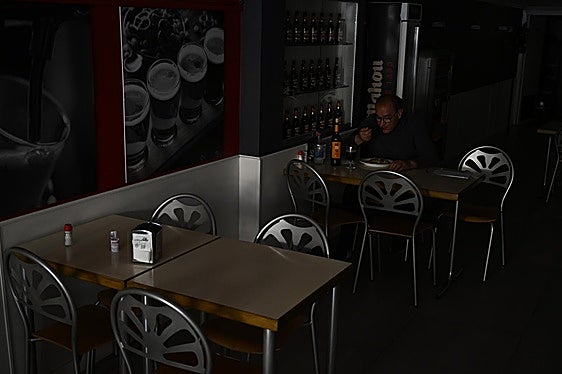 Una persona come en un restaurante a oscuras por el apagón