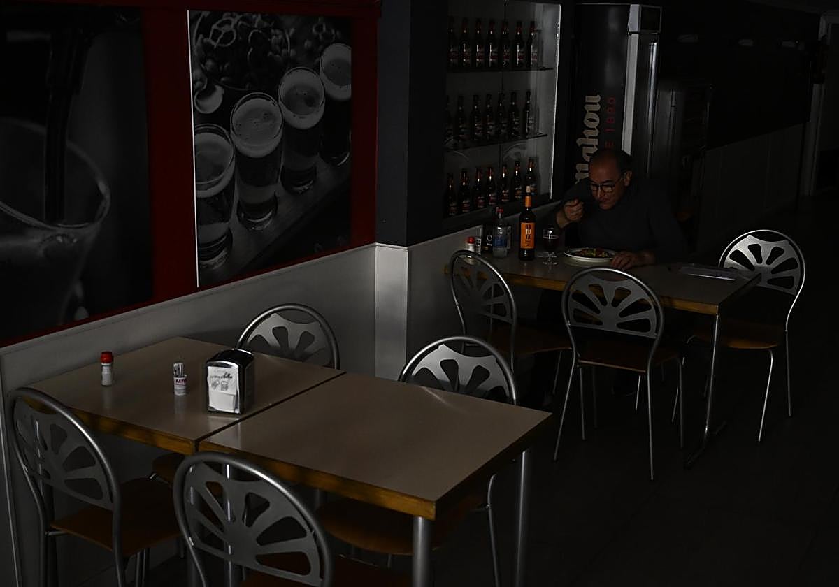 Una persona come en un restaurante a oscuras por el apagón