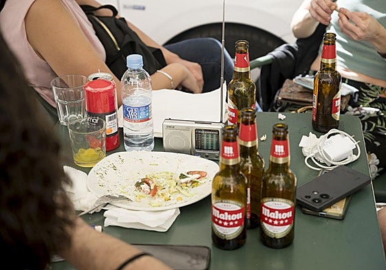 Un grupo de amigos toman algo mientras escuchan la radio en una terraza durante el apagón.