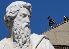 Bomberos colocan en el tejado de la Capilla Sixtina la chimenea que se utilizará para las fumatas.