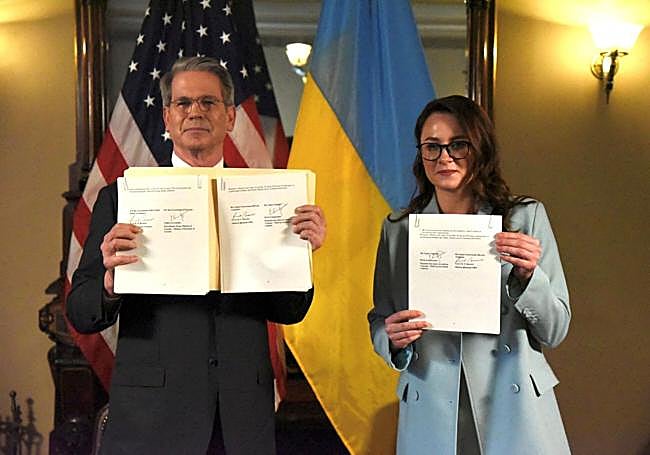 El secretario del Tesoro de EE UU, Scott Bessent, y la viceprimera ministra ucraniana, Yulia Svyrydenko, posan con el acuerdo de minerales tras su firma.