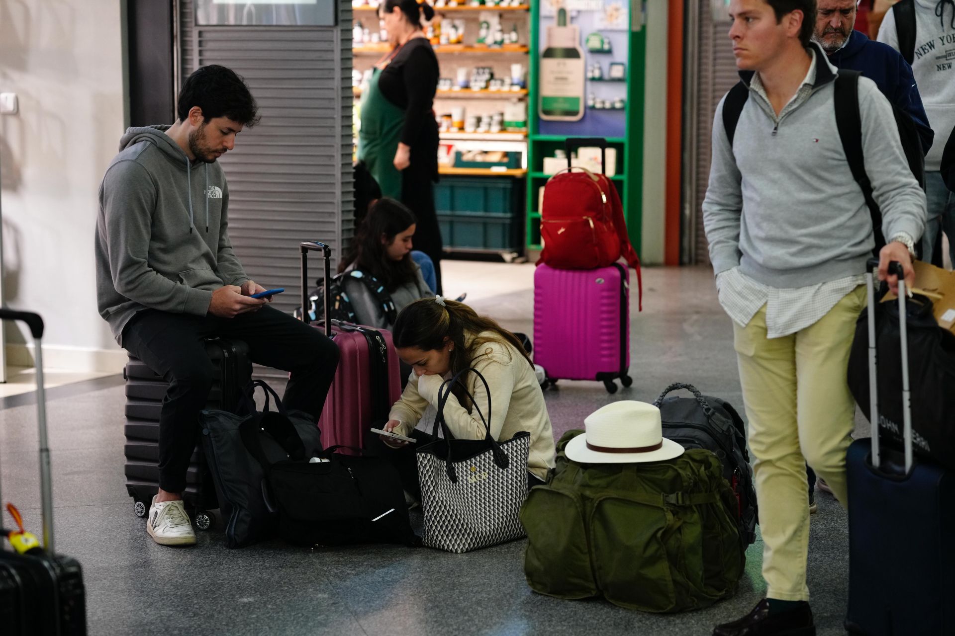Usuarios pendientes del móvil revisando el móvil mientras esperan la salida de sus trenes