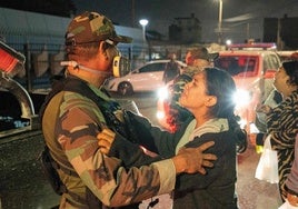 Una mujer habla con un Policía frente a la morgue a la que fueron trasladados los cuerpos de los 13 mineros peruanos asesinados.