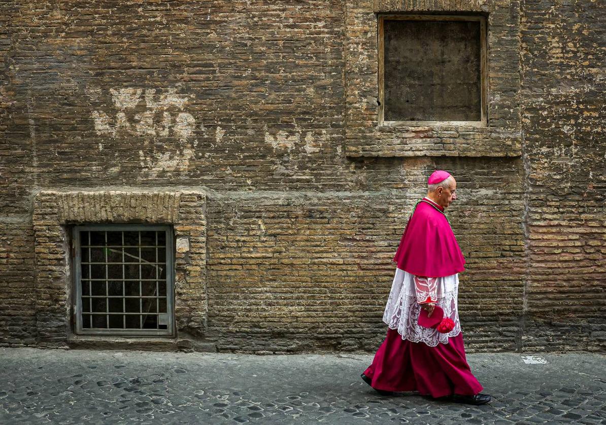 Un obispo católico camina por una calle trasera cerca del Vaticano momentos antes del cónclave.