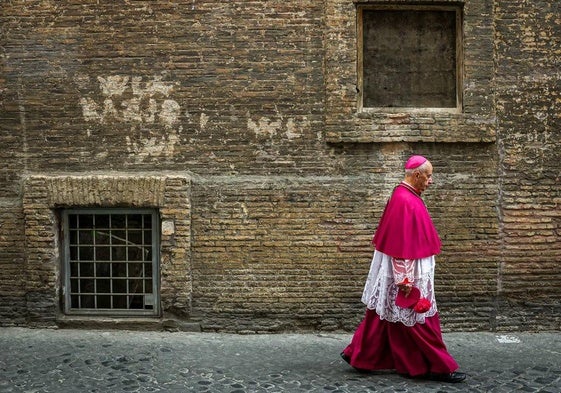 Un obispo católico camina por una calle trasera cerca del Vaticano momentos antes del cónclave.