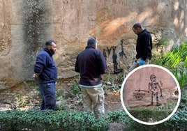 Trabajadores del Patronato de la Alhambra y el Generalife durante el proceso de borrado del grafiti en la mañana de este viernes. En el círculo, la pintada.