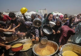 Familias palestinas desplazadas intentan conseguir una ración de comida en el campo de refugiados de Yabalia, en el norte de Gaza.