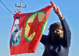 Una persona ondea una bandera con el retrato del fundador del PKK.