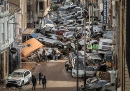 Vehículos amontonados en una calle tras las intensas lluvias de la fuerte dana en Alfafar, Valencia.