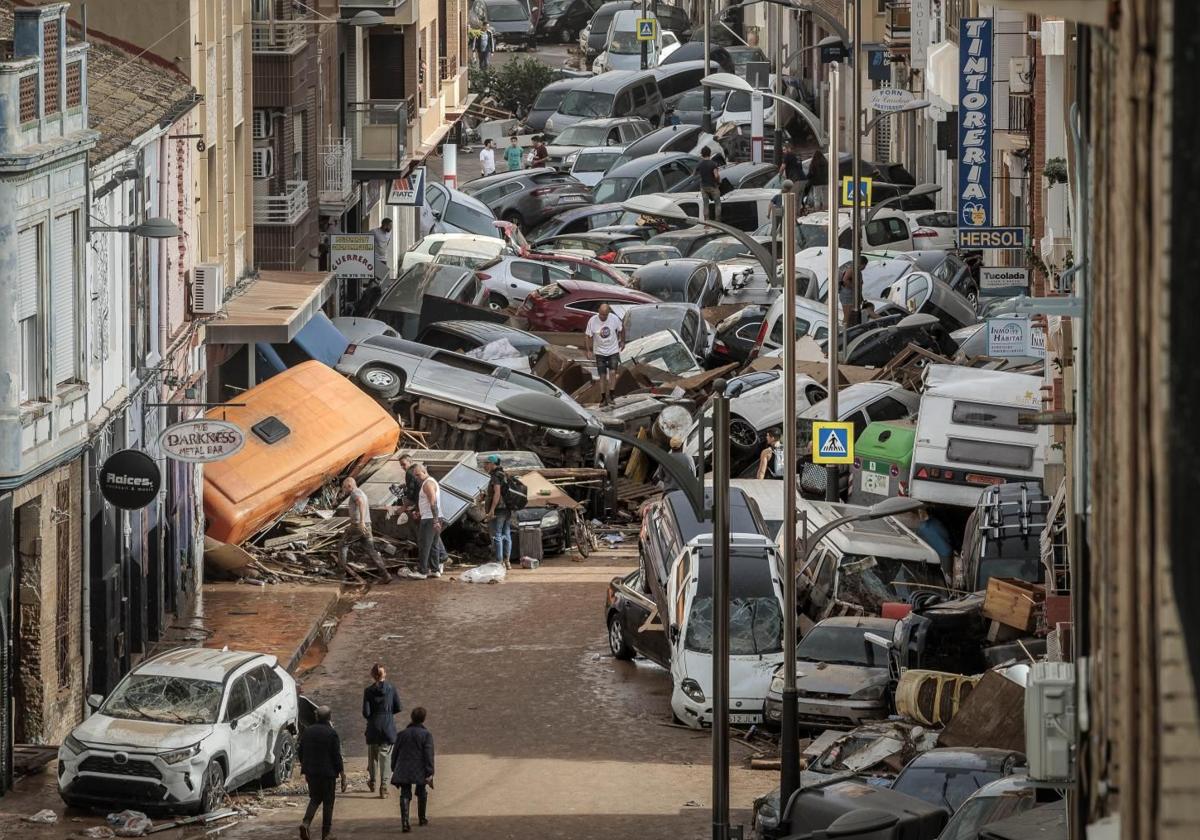 Vehículos amontonados en una calle tras las intensas lluvias de la fuerte dana en Alfafar, Valencia.