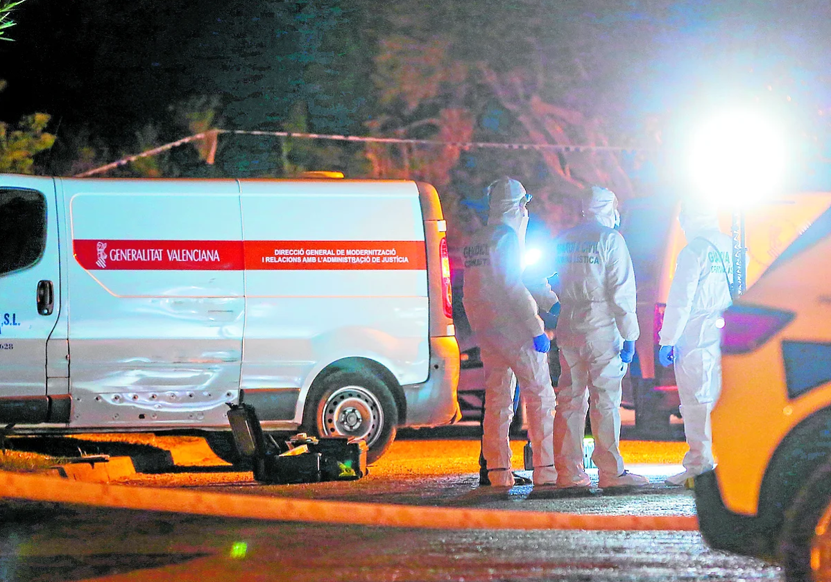 Agentes del Servicio de Criminalística, el 27 de febrero por la noche, junto al furgón del retén fúnebre.