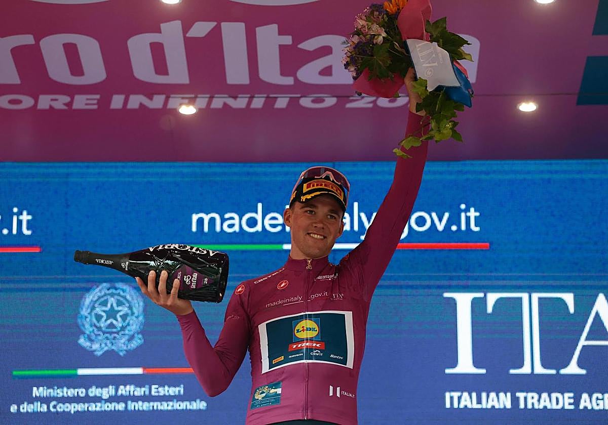 Mads Pedersen, vestido de rosa en el podio, celebra su victoria en la quinta etapa.