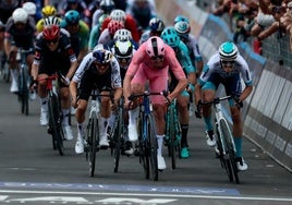 Mads Pedersen, de rosa, cruza la línea de meta con Edoardo Zambanini a su izquierda.