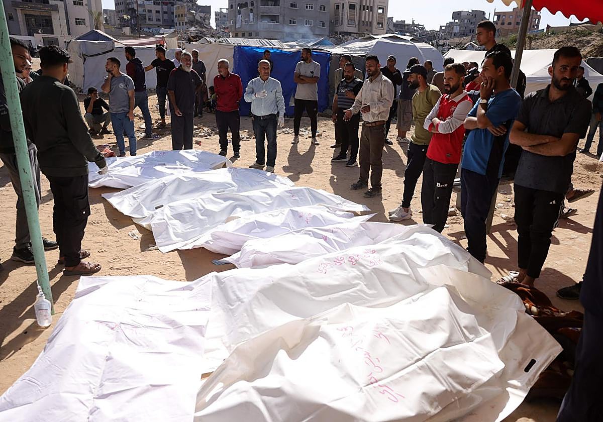 Ciudadanos velan los cuerpos de los palestinos muertos en un ataque israelí frente al hospital indonesio en Beit Lahia, en el norte de Gaza.