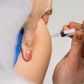 Una sanitaria vacuna a un niño contra el sarampión.