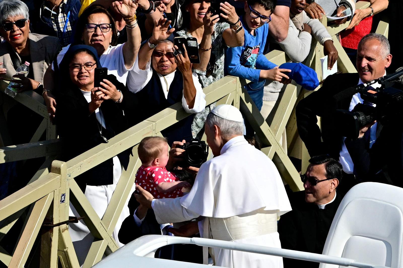 El papa León XIV saluda emocionado a los fieles desde su papamóvil.
