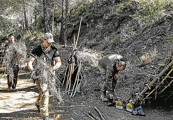 Alumnos del centro de superviviencia de Ojén acondicionan un refugio.