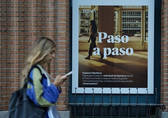 Una mujer frente a una entidad bancaria.