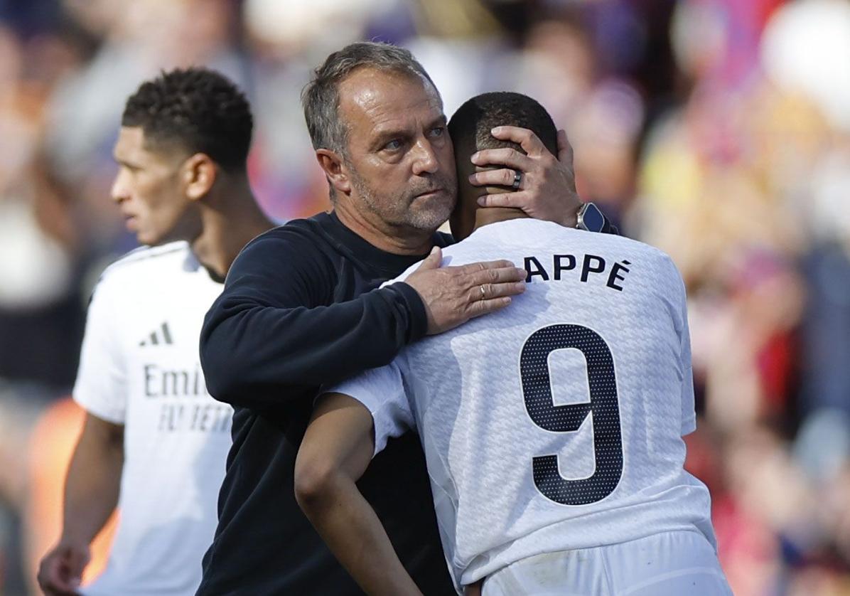 Hansi Flick consuela a Kylian Mbappé tras el clásico liguero disputado el 11 de mayo en Montjuic.