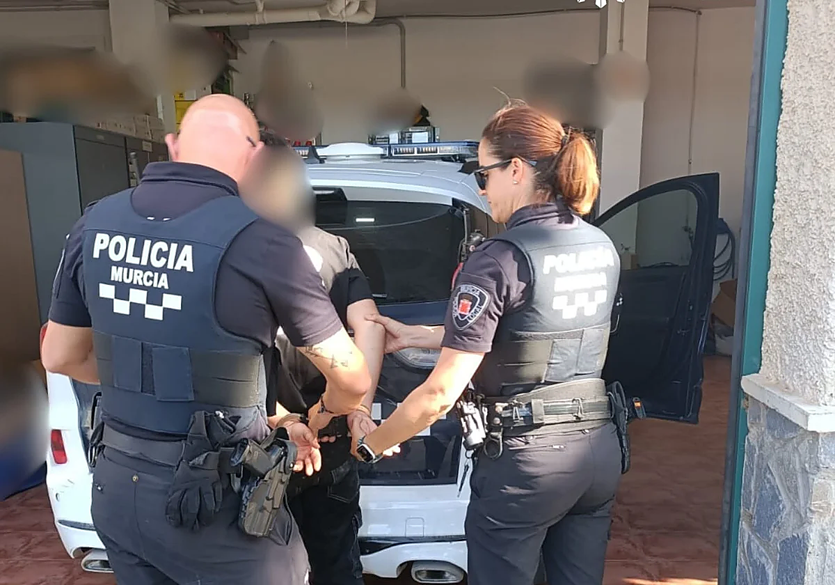 Dos agentes de la Policía Local de Murcia, trasladan al menor detenido.