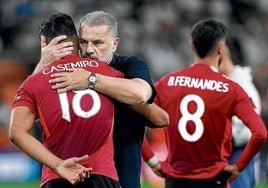 El entrenador del Tottenham, Angelo Postecoglou, consuela a Casemiro, con Bruno Fernandes en segundo plano.