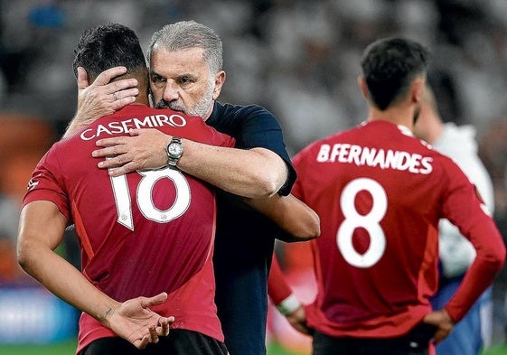 El entrenador del Tottenham, Angelo Postecoglou, consuela a Casemiro, con Bruno Fernandes en segundo plano.