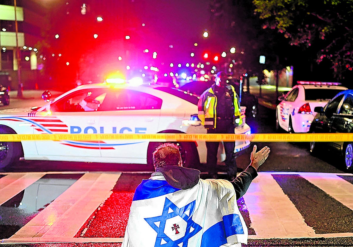 Un ciudadano con la bandera de Israel junto a la zona del atentado mortal registrado el miércoles en Washington.