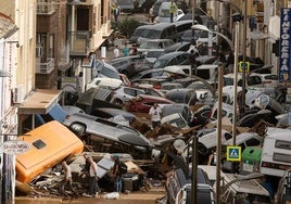 Vehículos amontonados en una calle tras las intensas lluvias en Picaña (Valencia)
