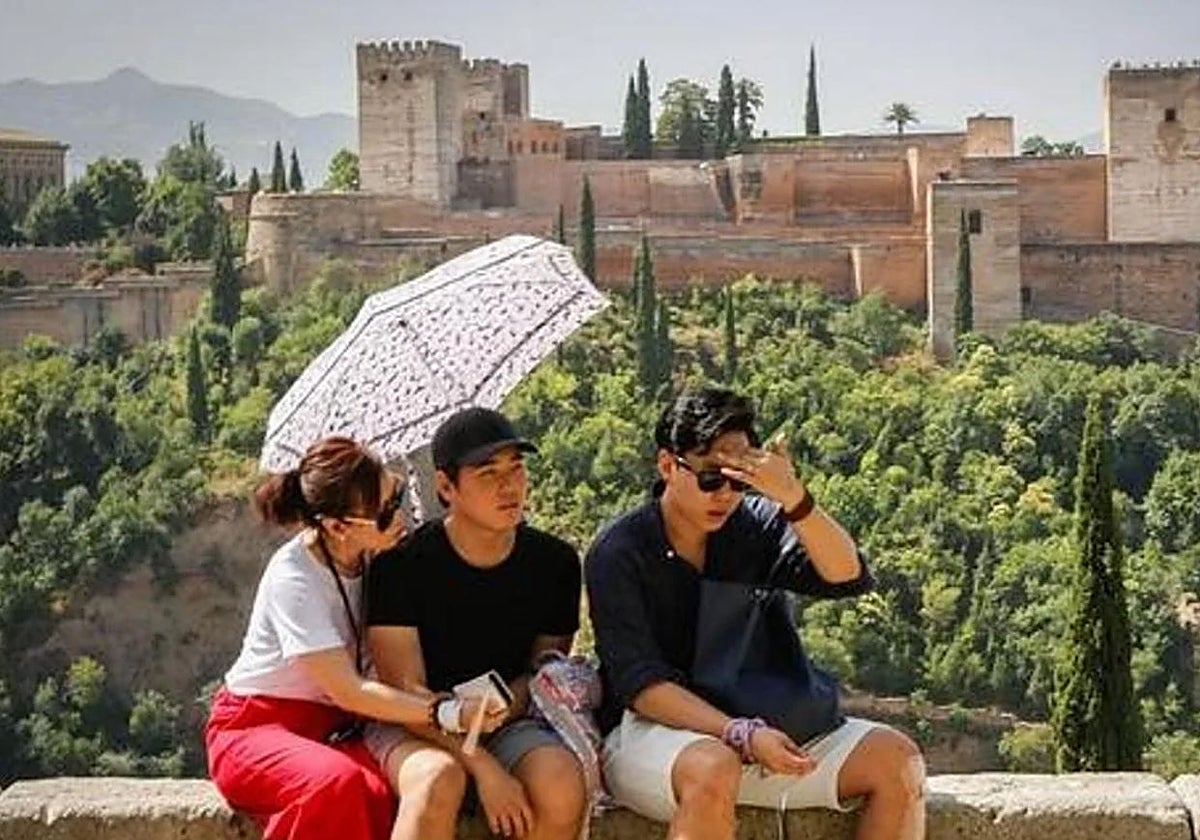 Turistas se protegen del sol en Granada.