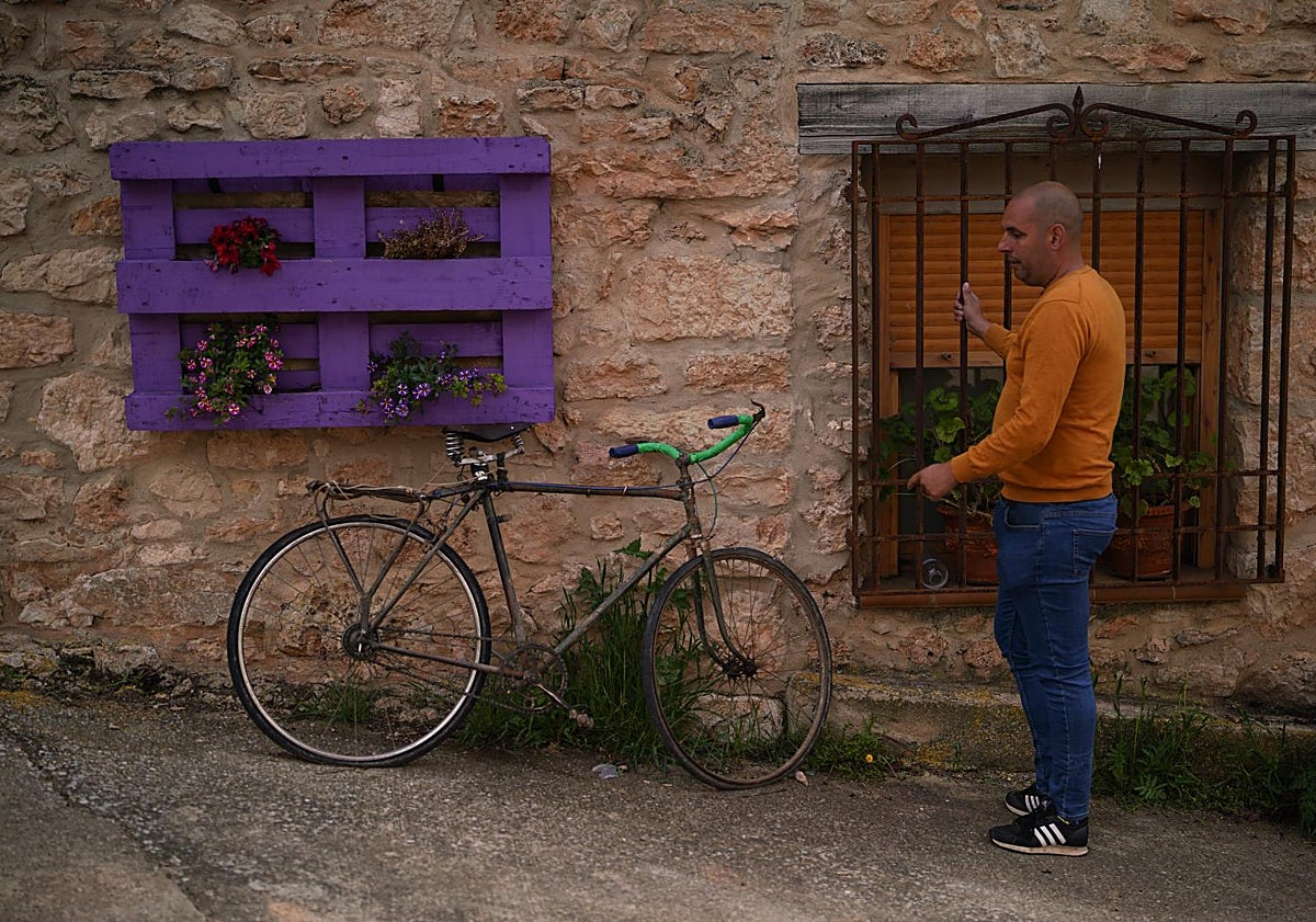 Imagen principal - De arriba abajo, Fernando delante de su casa de piedra, que construyeron sus tatarabuelos; bebiendo agua en la fuente de la plaza de Benamira; y en el local social del pueblo donde hay un futbolín.
