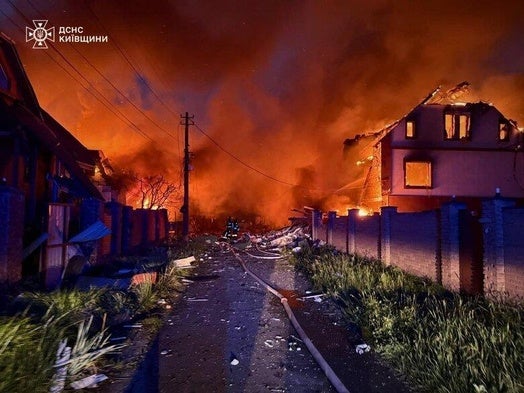 Una calle a las afueras de Kiev flanqueada por edificios destruidos y en llamas tras el ataque nocturno.